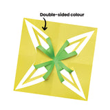 A square of yellow Collagami paper cut and folded into a four-pointed star design, with green strips curling outward from the centre, revealing the contrasting colour on the reverse. An arrow points to the folded form with the annotation ‘Double-sided colour’.