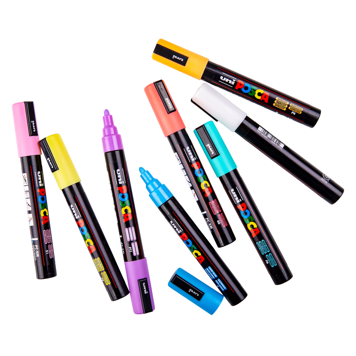 Assorted Uni POSCA pastel paint markers arranged loosely on a white background, with some caps removed to show the medium bullet tips. Colours include peach, pink, yellow, mint, blue, white and purple.