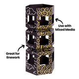 A stacked geometric paper structure decorated with flowing white and metallic gold linework is shown against a neutral background. Black annotation text reads “Great for linework” and “Use with Mixed Media,” highlighting the crisp, opaque marker details.