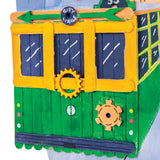 Close-up detail of a painted tram artwork constructed from wooden craft sticks, showing layered sticks, painted windows, gears and decorative elements.