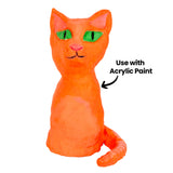 An air drying clay cat painted bright orange, sitting upright with pointed ears, wide green eyes with black slit pupils, a pink nose and a long curled tail. The paint has a glossy sheen over the modelled surface. A black annotation reads "Use with Acrylic Paint" with an arrow.