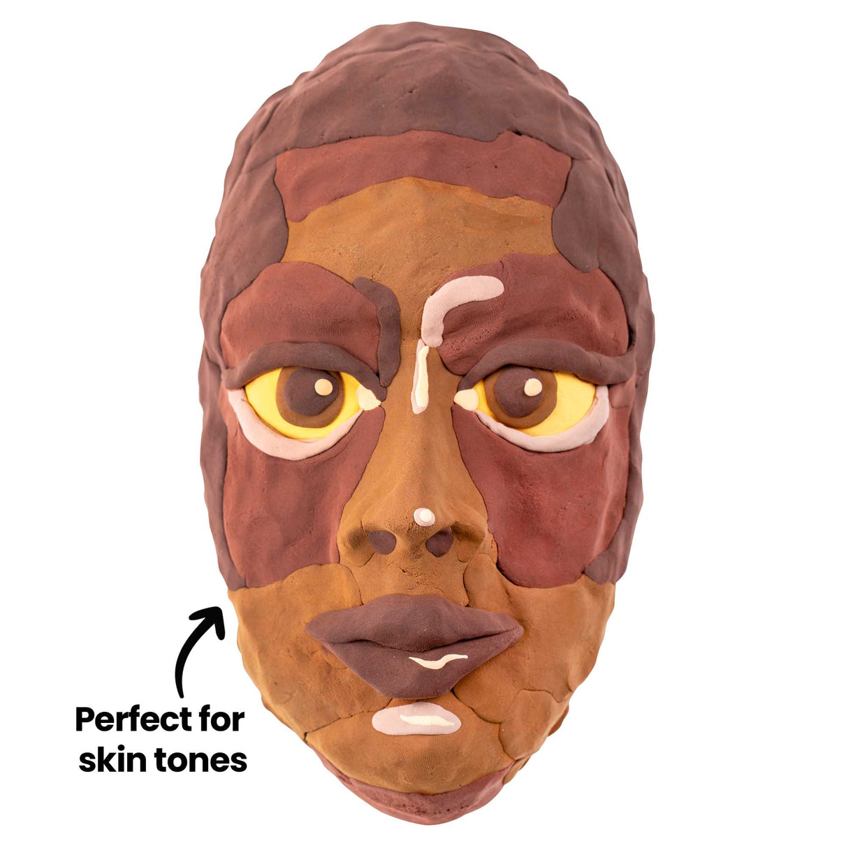 Front-facing sculpted face made from layered earth-tone Paper Magiclay. On-image annotation reads Perfect for skin tones with an arrow pointing to the cheek area. Browns, ochres and creams form facial planes, eyes, nose and lips.