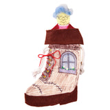 A Zart Calico Stocking transformed into an "old woman in a shoe" character, printed with wood-plank shading, a stitched patch and an arched window with flower box. A felt collar and brown sole are added, topped with a felted grandmother face with glasses and blue hair.