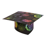 A single decorated Scratch Graduation Hat covered in firework-style bursts and spirals scratched from the black surface to reveal bright rainbow colours — pink, orange, yellow, green, blue and purple. The mortarboard shape is shown at an angle against a white background.