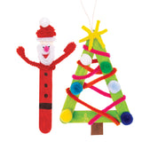 Two festive Popstick Natural - Giant artworks are displayed against a pale grey background. One features a painted red Santa figure with chenille stick arms, pom pom details, and googly eyes, while the other forms a green Christmas tree decorated with colourful pom poms and fuzzy pipe cleaners.