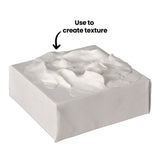 White rectangular block of Paper Magiclay with smooth sides and textured top surface showing thick, sculptural application creating dimensional peaks and valleys. Annotation reads "Use to create texture" with arrow pointing to the textured surface, demonstrating the product's ability to build relief effects in mixed-media artwork.