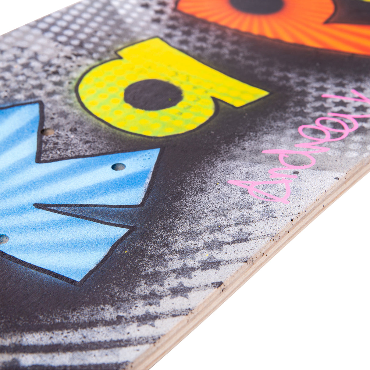 Close-up of a painted skateboard deck showing layered spray paint, stencilled textures and bold lettering, highlighting surface detail and paint coverage.