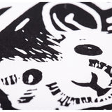 Close-up of the printed mouse face in high-contrast black ink on white paper. Solid black areas define the eye, ear and fur, while small white carved marks create texture within the dark shapes. Edges appear crisp and clearly defined.