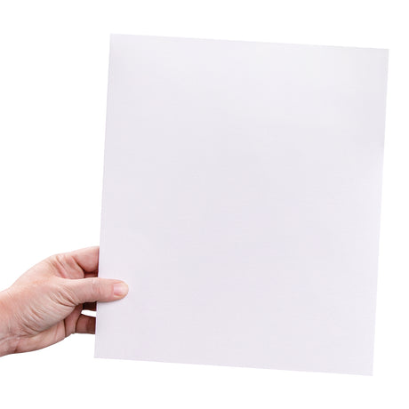 A hand holds a larger square canvas board against a light background. The white primed surface shows a visible woven canvas texture, designed for painting and mixed media.