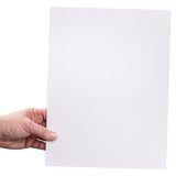 A hand holds a rectangular canvas board upright against a light background. The primed white surface shows the fine fabric texture of the canvas. The board has a rigid backing and clean square edges.