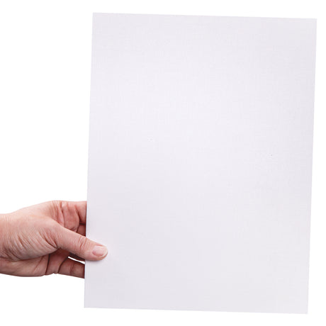 A hand holds a rectangular canvas board upright against a light background. The primed white surface shows the fine fabric texture of the canvas. The board has a rigid backing and clean square edges.