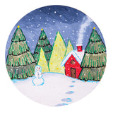 A hand-painted sample made using a Zart Magnetic Canvas Board Round, depicting a snowy night scene with a red cottage, glowing yellow-lit trees and dark green pines under a starry navy sky. A smiling snowman stands nearby, with pale blue footprints trailing across the snow-covered ground.