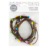 Value Craft Decorative Wire Flower Bud Garland in clear packaging, featuring twisted brown wire adorned with colourful fabric flower buds in pink, purple, yellow, green, and blue. Header displays "CREATE, MAKE & DECORATE" text with pastel polka dot pattern. Pack contains five flexible wire garlands perfect for craft projects and decorative displays.