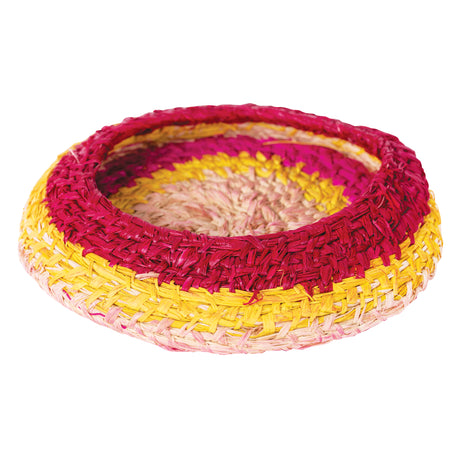 Handwoven circular raffia basket displaying natural fibre texture in concentric colour bands of pale pink, bright yellow, vibrant magenta, and orange. The shallow bowl shape showcases traditional coiling and weaving techniques, demonstrating the versatile craft possibilities of Raffia Natural for creative projects and educational weaving activities.