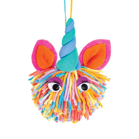 Colourful yarn pom pom craft resembling a unicorn, made from soft multicoloured acrylic wool strands. Features a twisted teal and blue horn, bright felt ears in pink and orange, and glossy googly eyes. The dense, shaggy texture creates a vibrant, tactile surface.