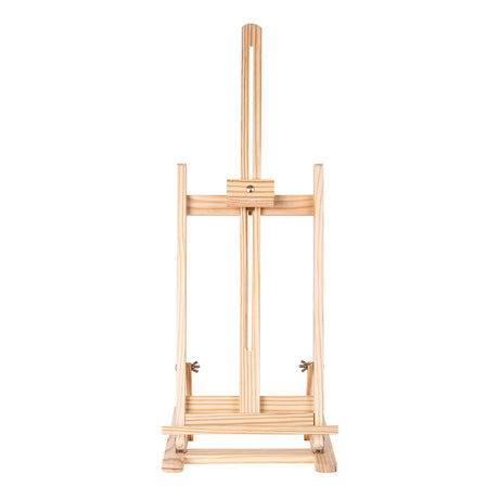 Front view of a natural wood tabletop easel with a slim vertical frame, adjustable centre support and horizontal canvas ledge. The easel is photographed against a light grey background, showing visible woodgrain texture, brass fittings and a compact rectangular base with clean symmetrical lines.