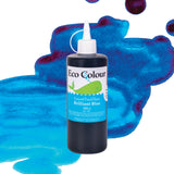 A bottle of Eco Colour Liquid Food Dyes labelled Brilliant Blue, 500ml, featuring a white pointed nozzle cap and a label showing a whale illustration. The dark blue liquid is described as Non Toxic, shown against a backdrop of blue and magenta watercolour splashes.