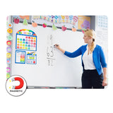 Teacher in blue cardigan writing mathematics equations on whiteboard decorated with Giggle & Grow Magnetic Calendar Bulletin Board Set featuring colourful October calendar, days of the week chart, weather tracker, and decorative fruit garland border. MAGNETIC icon displayed in bottom left corner showing magnet symbol.