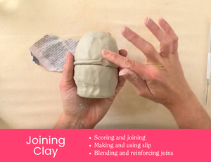 Zart Education Professional Learning The Essentials of Clay image showing hands smoothing a clay join around a rounded grey clay form. A clay tool and paper rest nearby on the tabletop. Pink banner text reads: “Joining Clay” with “Scoring and joining”, “Making and using slip”, and “Blending and reinforcing joins”.