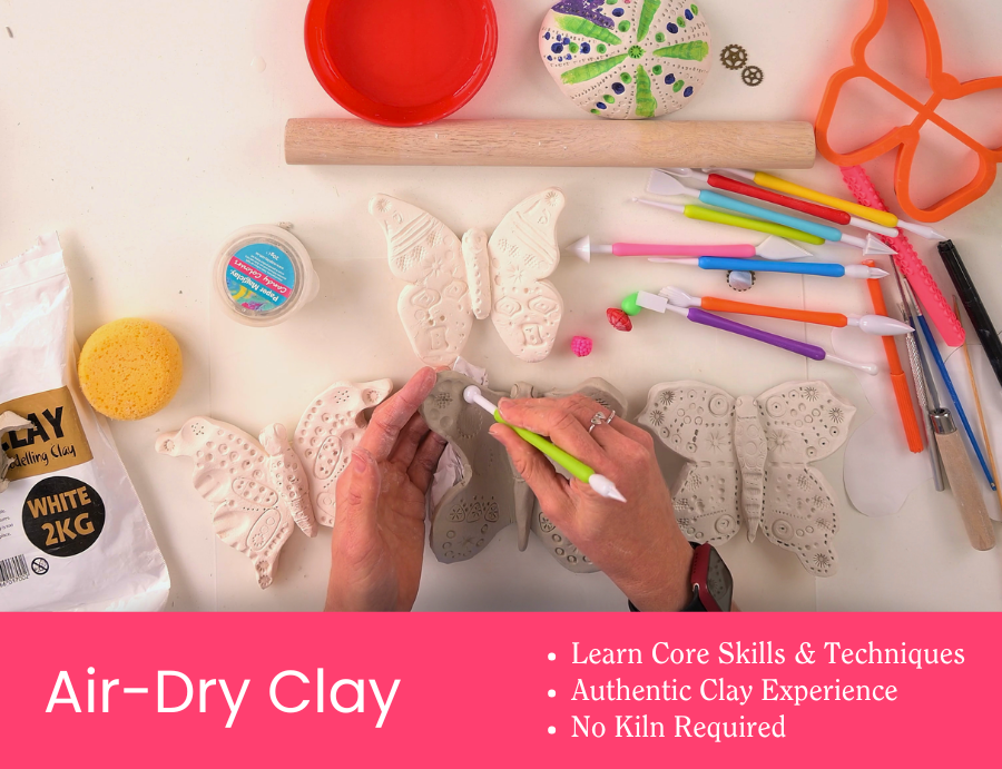 Workshop tile showing hands carving details into grey air-dry clay butterfly shapes using a green sculpting tool. Around the table are clay tools, a wooden rolling pin, a sponge, and bright coloured modelling tools. Pink banner text reads “Air-Dry Clay” with dot points: “Learn Core Skills & Techniques”, “Authentic Clay Experience”, “No Kiln Required”. Credit: Zart Education PL The Essentials of Modelling.