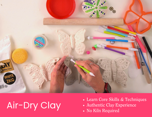 Workshop tile showing hands carving details into grey air-dry clay butterfly shapes using a green sculpting tool. Around the table are clay tools, a wooden rolling pin, a sponge, and bright coloured modelling tools. Pink banner text reads “Air-Dry Clay” with dot points: “Learn Core Skills & Techniques”, “Authentic Clay Experience”, “No Kiln Required”. Credit: Zart Education PL The Essentials of Modelling.