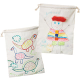 Two natural calico drawstring bags displayed with children’s drawings. One shows colourful dinosaurs outlined in bright marker, while the other features a figure labelled “Anthony” with a rainbow-striped outfit and buttons. The fabric appears soft, slightly wrinkled, and textured.