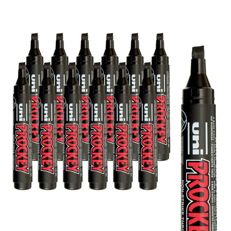 A collection of black Uni Prockey markers with broad chisel tips arranged in layered rows on a pale grey background. An enlarged cropped marker on the right emphasises the angled chisel nib and the bold red and white “PROCKEY” branding across the black barrel.