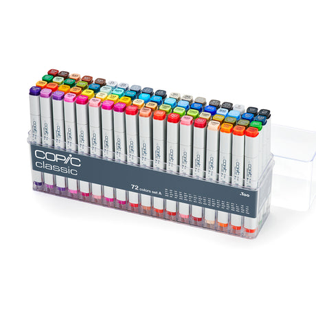 A clear plastic case holding Copic Classic alcohol markers arranged in rows. White barrels with grey ends and coloured caps show a wide colour range, each labelled with alphanumeric codes. Front label reads “COPIC classic,” “72 colours set A,”