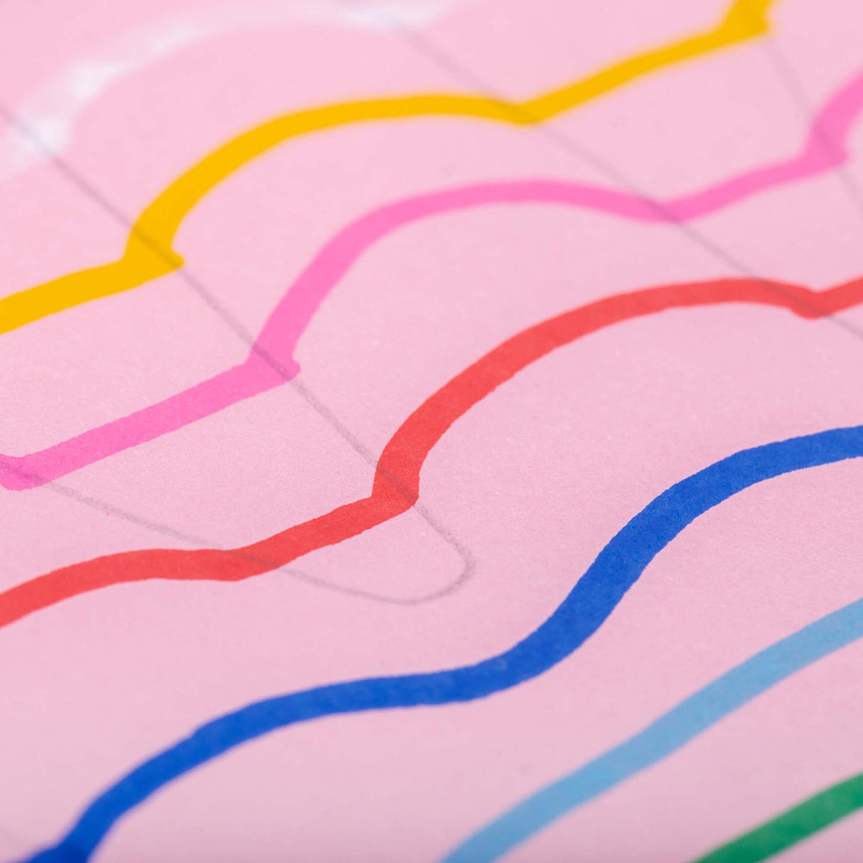 Close-up view of bright curved lines drawn with POSCA paint markers on pink paper, showing smooth opaque strokes in yellow, pink, red, blue and green.