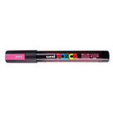 A uni POSCA paint marker shown horizontally against a white background. The glossy black cylindrical barrel carries the colourful POSCA branding and is topped by a uni clip, with the coloured cap or exposed bullet nib indicating the paint colour inside.
