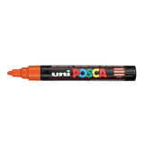 A uni POSCA paint marker shown horizontally against a white background. The glossy black cylindrical barrel carries the colourful POSCA branding and is topped by a uni clip, with the coloured cap or exposed bullet nib indicating the paint colour inside.