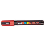 A uni POSCA paint marker shown horizontally against a white background. The glossy black cylindrical barrel carries the colourful POSCA branding and is topped by a uni clip, with the coloured cap or exposed bullet nib indicating the paint colour inside.
