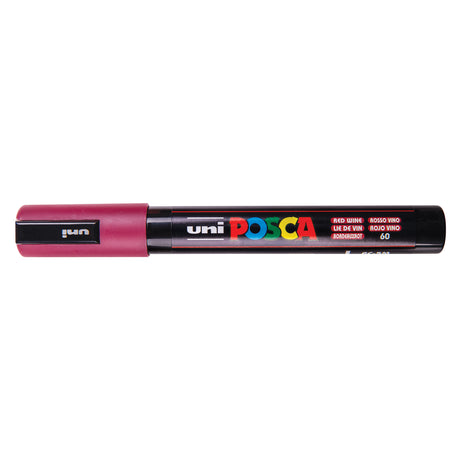 A uni POSCA paint marker shown horizontally against a white background. The glossy black cylindrical barrel carries the colourful POSCA branding and is topped by a uni clip, with the coloured cap or exposed bullet nib indicating the paint colour inside.