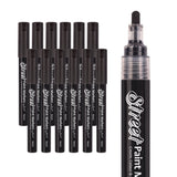 A group of Street Paint Markers by Zart with black caps is arranged in rows beside a close-up of the marker tip. The glossy black barrels feature white branding, and the rounded nib appears saturated with dark pigment.