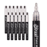 A set of Street Paint Markers by Zart with silver caps is shown alongside a close-up of the marker tip. The nib has a metallic silver sheen, complementing the smooth black barrel and bright reflective cap finish.