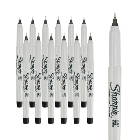 Sharpie Ultra Fine Permanent Marker pens shown as a pack of twelve, arranged in two staggered rows behind a larger single pen on the right. Each glossy white barrel tapers at the top to a small metal tip holding a fine black point, with a black end plug at the base.