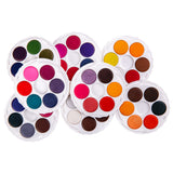 Multiple open Micador Brilliant Watercolours discs overlap in a clustered arrangement on a white background. The round white trays display many colour pans, including bright pinks, reds, oranges, yellows, blues, greens, purples, browns, black and white.