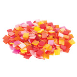 A rounded pile of Zart Deco mosaic tiles in the warm colour range. Small glossy squares mix reds, oranges, pinks, crimson and yellow, some translucent and some opaque. Heaped together, the tiles show off a bright, energetic palette with light glancing off their smooth surfaces.