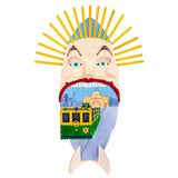 A Zart Wooden Surfboard shaped and painted into a face with a wide-mouthed, teeth-baring expression, fanned with a mohawk of yellow craft sticks. Inside the open red-lipped mouth sits a detailed cityscape painting featuring a green and yellow number 35 tram, a domed heritage building, and city skyscrapers.